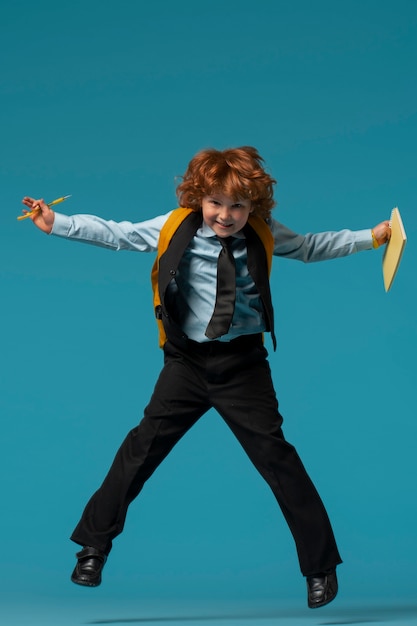 Portret młodego chłopca ucznia w mundurku szkolnym, skoków w powietrzu