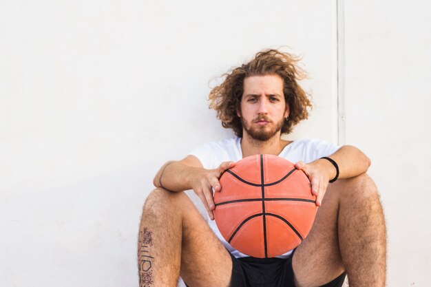 Portret młodego człowieka obsiadanie z koszykówką