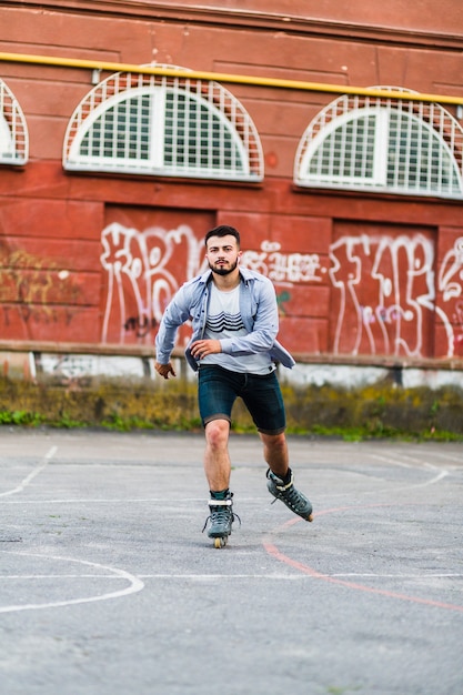 Portret młodego człowieka rollerskating w łyżwowym parku