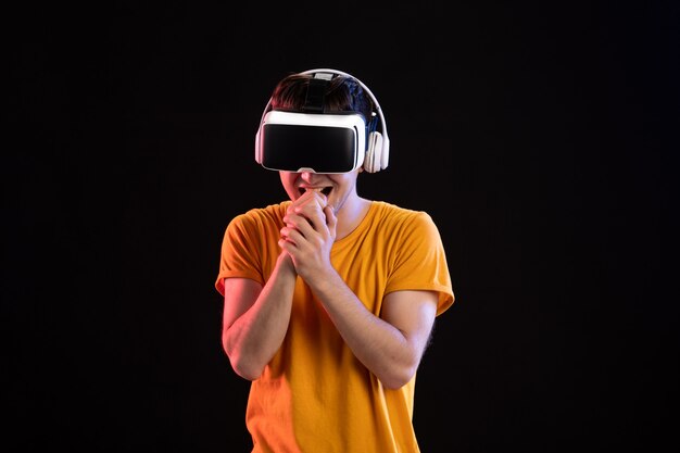 Portret młodego mężczyzny grającego w vr w słuchawkach na ciemnej podłodze gry wizualne widzenie d tech