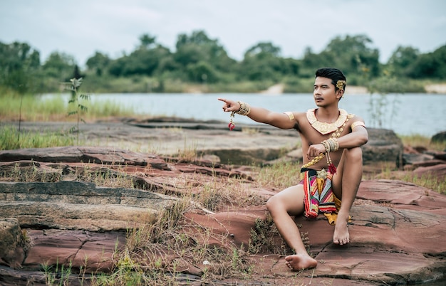 Portret młodego mężczyzny w tradycyjnym stroju pozuje w przyrodzie w Tajlandii