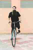 Bezpłatne zdjęcie portret młodego mężczyzny z długą brodą, jazda na rowerze