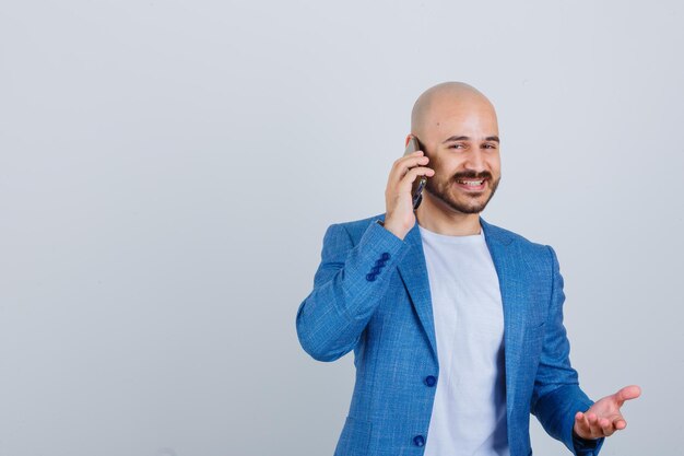 Portret młodego pewnego siebie mężczyzny rozmawiającego przez telefon