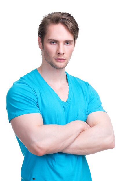 Portret młodego przystojnego mężczyzny w niebieskiej koszuli skrzyżowanymi rękami - na białym tle.