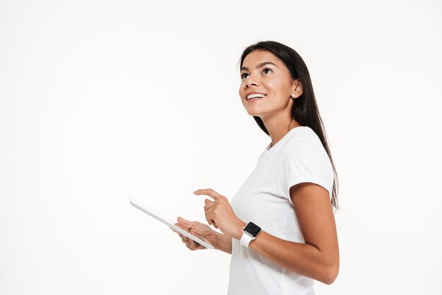 Portret młodego szczęśliwego kobiety mienia pastylki komputer