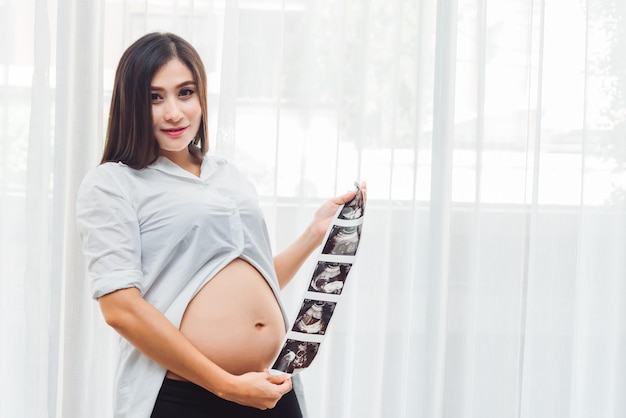 Portret Młodej Dorosłej Azjatyckiej Kobiety W Ciąży Trzymającej Zdjęcie Usg Ze Szczęśliwym