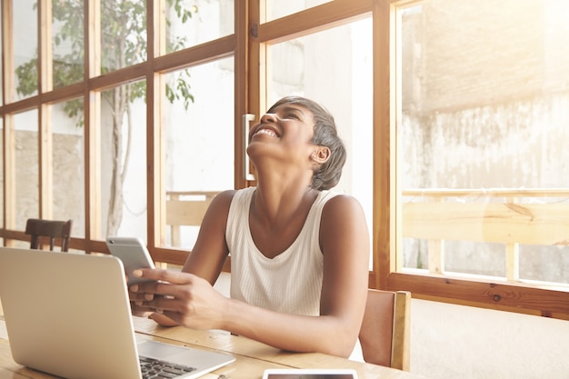 Portret młodej kobiety brunetka siedzi w kawiarni z laptopem