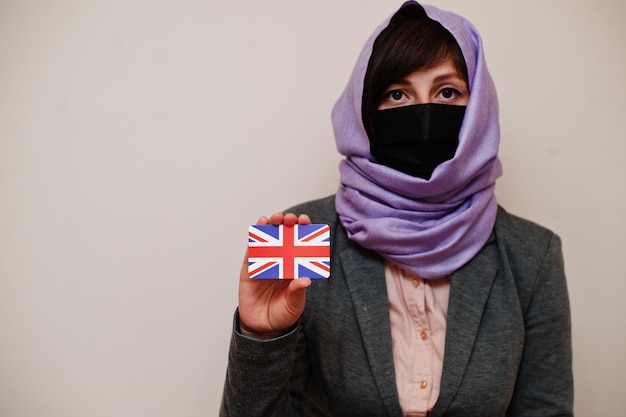 Portret Młodej Kobiety Muzułmańskiej Noszącej Formalny Strój Chronić Maskę Na Twarz I Hidżab Na Głowę Trzymaj Kartę Flagi Wielkiej Brytanii Na Na Białym Tle Koncepcja Kraju Koronawirusa Darmowe Zdjęcia