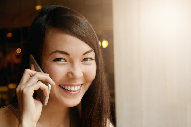 Portret młodej kobiety z brunetką za pomocą telefonu