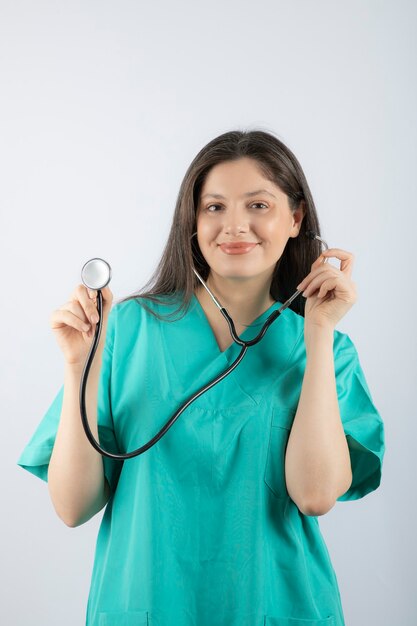 Portret młodej lekarki ze stetoskopem w mundurze.