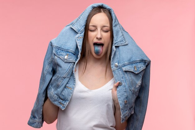 Portret młodej nastolatki pokazującej jej niebieski język