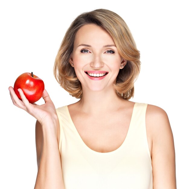 Portret młodej uśmiechnięta zdrowa kobieta z czerwonym jabłkiem na białym tle.