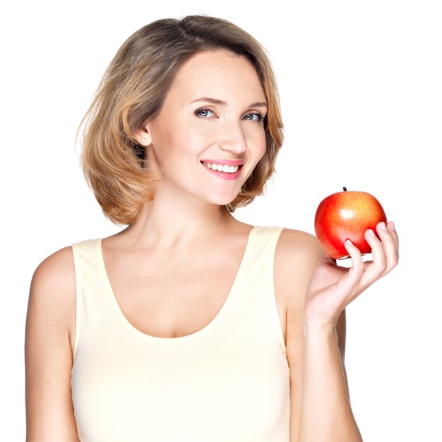 Portret młodej uśmiechniętej zdrowej kobiety z czerwonym jabłkiem - na białym tle.
