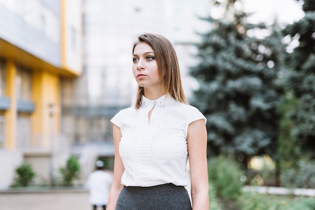 Portret młody bizneswoman patrzeje daleko od przy outdoors