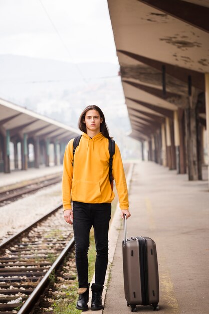 Portret młody człowiek przy stacją kolejową