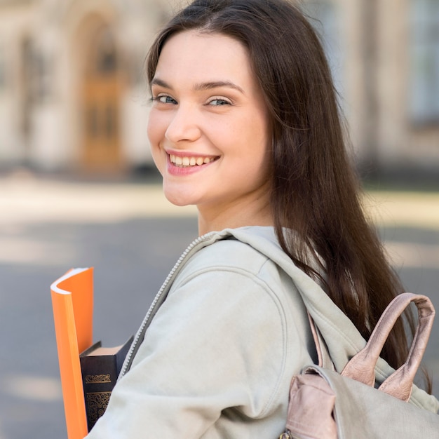 Bezpłatne zdjęcie portret młody studencki szczęśliwy być z powrotem przy uniwersytetem