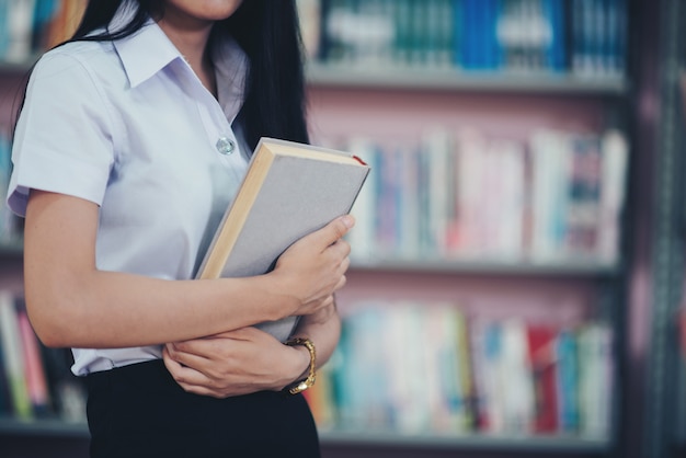 Portret młody uczeń czyta książkę w bibliotece