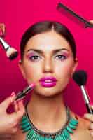 Bezpłatne zdjęcie portret modelki o doskonałej skórze, jasnym makijażu, dużych różowych ustach i naszyjniku