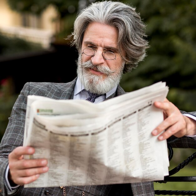 Portret modny dojrzały mężczyzna czytania gazety
