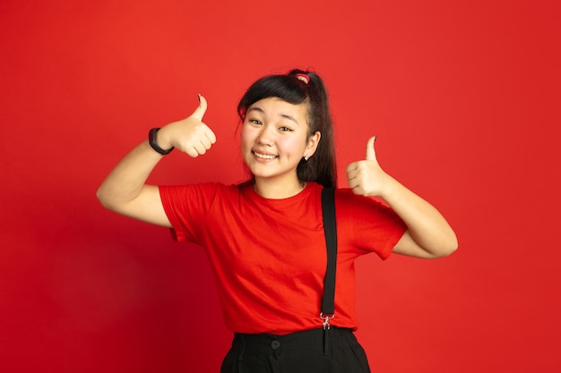 Portret nastolatka azjatyckiego na białym tle na czerwoną przestrzeń