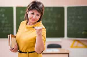 Bezpłatne zdjęcie portret nauczyciela wskazując w klasie