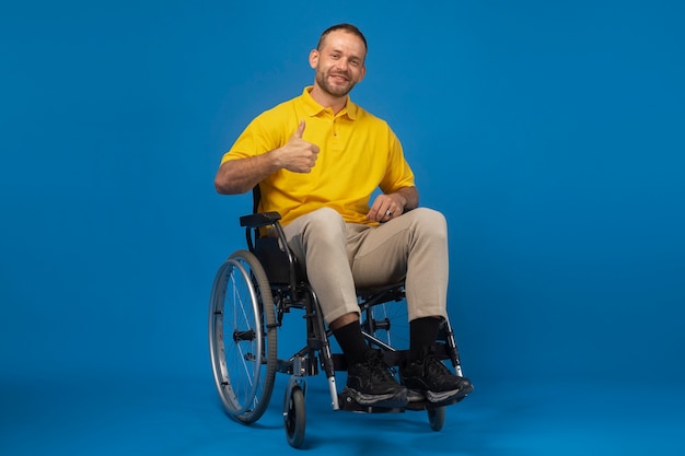 Portret niepełnosprawnego mężczyzny na wózku inwalidzkim, który daje aprobatom