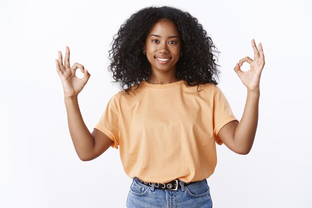 Portret pewnego siebie uśmiechniętego Afro-Amerykanina pokazującego w porządku gest