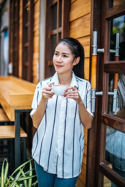 Portret piękna azjatykcia kobieta relaksuje przy kawiarnią
