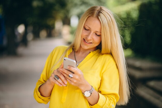 Portret piękna blondynki dziewczyna opowiada na telefonie