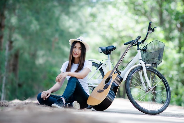 Portret Piękna Dziewczyna Bawić Się Gitarę Z Rowerem Przy Naturą