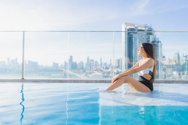 Portret piękna młoda azjatycka kobieta relaksuje wypoczynek przy basenie