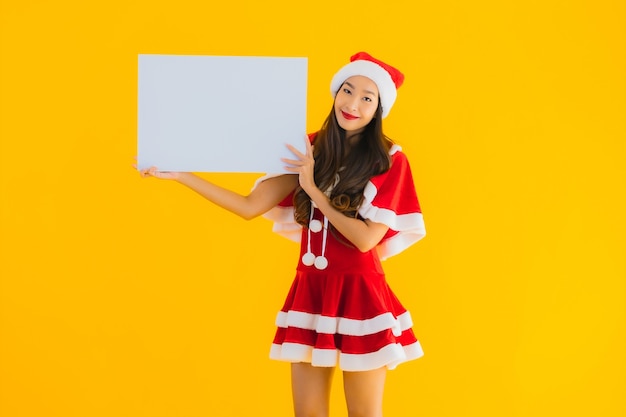 Bezpłatne zdjęcie portret piękna młoda azjatycka kobieta ubrania świąteczne i uśmiech kapelusz z pustą deską