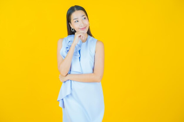 Portret piękna młoda azjatycka kobieta uśmiecha się na żółto