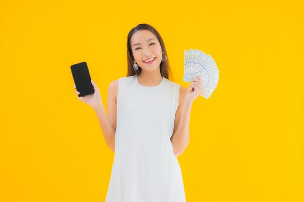 Portret piękna młoda azjatycka kobieta z gotówką