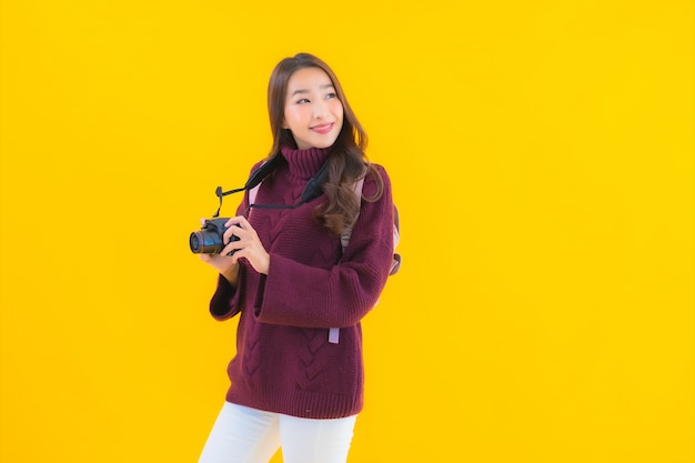 Portret piękna młoda azjatycka kobieta z plecakiem i aparatem do podróży na wakacje