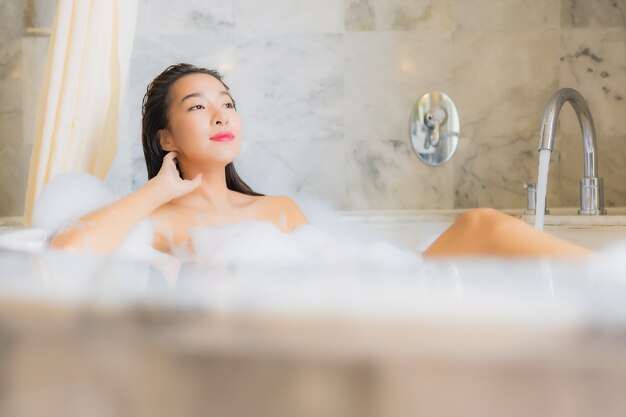 Portret piękna młoda azjatykcia kobieta relaksuje kąpieli