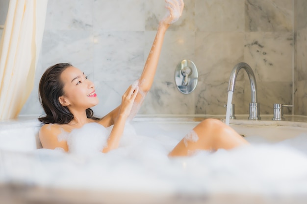 Portret piękna młoda azjatykcia kobieta relaksuje kąpieli