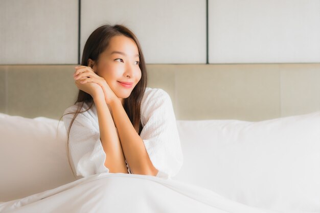 Portret piękna młoda azjatykcia kobieta relaksuje szczęśliwego uśmiech w sypialni