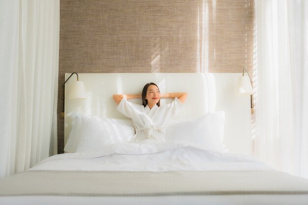 Portret piękna młoda azjatykcia kobieta relaksuje uśmiech na łóżku w sypialni