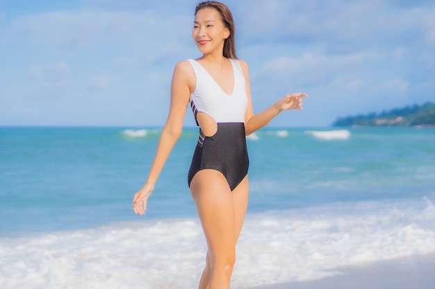 Portret piękna młoda azjatykcia kobieta relaksuje uśmiech wokół plaży i oceanu w wakacje wakacje