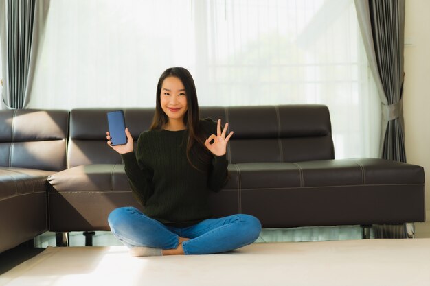 Portret piękna młoda azjatykcia kobieta używa mądrze telefon komórkowego