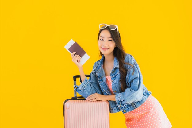 Portret piękna młoda azjatykcia kobieta z bagaż podróży torbą z paszportem i abordaż przepustki biletem