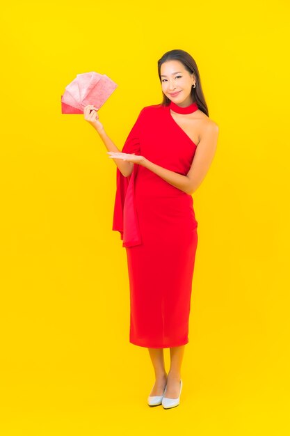 Portret piękna młoda azjatykcia kobieta z czerwoną kopertą list