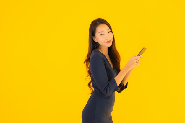 Portret piękna młoda azjatykcia kobieta z telefonem