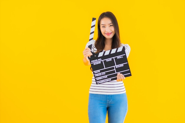 Portret piękna młoda azjatykcia kobiety przedstawienia clapper filmu deska