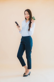 Portret piękna młoda biznesowa azjatykcia kobieta z telefonem i kartą kredytową