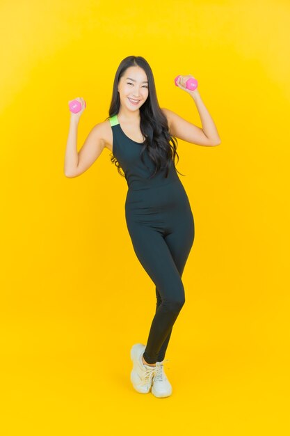 Portret piękna młoda kobieta Azji nosić strój siłowni trzymając hantle