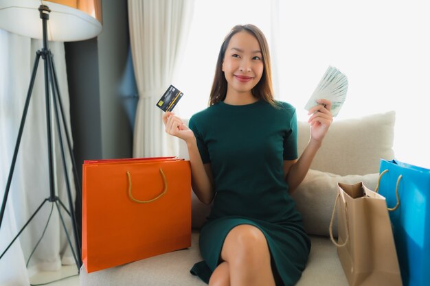 Portret piękne młode azjatykcie kobiety używa kredytową kartę dla online zakupy