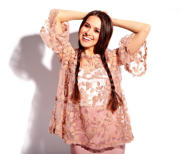 Portret pięknej kaukaski uśmiechnięta brunetka modelka z podwójnymi warkoczami w jasne różowe lato stylowe ubrania