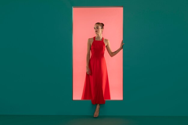 Portret pięknej kobiety pozującej w lejącej się czerwonej sukience